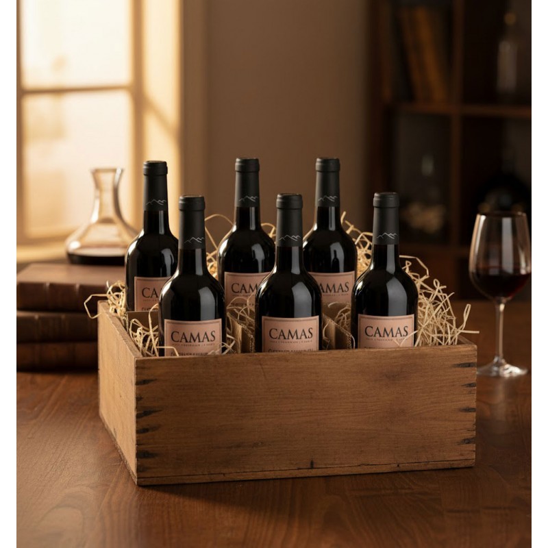 Six bouteilles de vin rouge de la marque CAMAS, soigneusement disposées dans une caisse en bois vieilli, garnie de paille.Evoquent l'authenticité et la tradition de la viticulture, suggérant un produit de qualité supérieure prêt à être dégusté. Un verre de vin rouge partiellement rempli et une carafe à décanter qui soulignent l'expérience de dégustation et l'appréciation du vin. les arômes et les saveurs qui pourraient émaner de ces bouteilles, en particulier s'il s'agit d'un Sauvignon Cabernet.