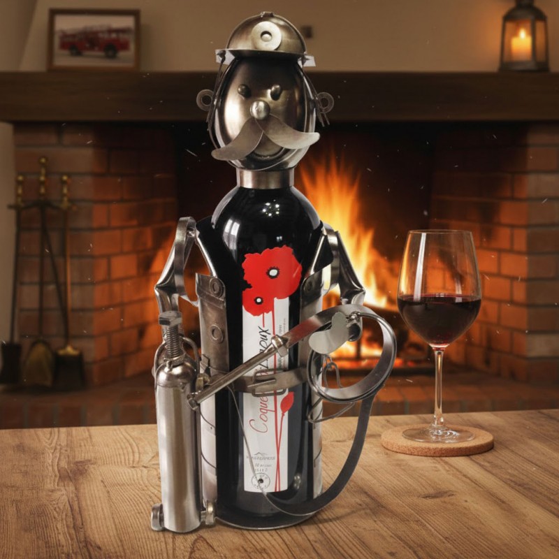 Porte bouteille la structure artisanale en métal (écrous, plaques et tiges soudées) représentant un pompier avec son casque, sa moustache et ses accessoires.Il contient une bouteille de vin rouge le coquelicot.