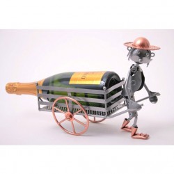 Un porte-bouteille décoratif en métal représentant un petit personnage stylisé poussant une brouette.
Le personnage est fabriqué en métal gris et cuivre, avec un chapeau en métal cuivré, des pieds plats et des détails mécaniques qui lui donnent un style artisanal.
Dans la brouette, on voit une grande bouteille de vin ou de champagne, couchée horizontalement. Le support métallique qui sert de brouette est composé de barres en acier et de roues cuivrées assorties au reste de la sculpture.
L'ensemble a une apparence artisanale, humoristique et décorative, typique des porte-bouteilles en métal façonnés à la main.